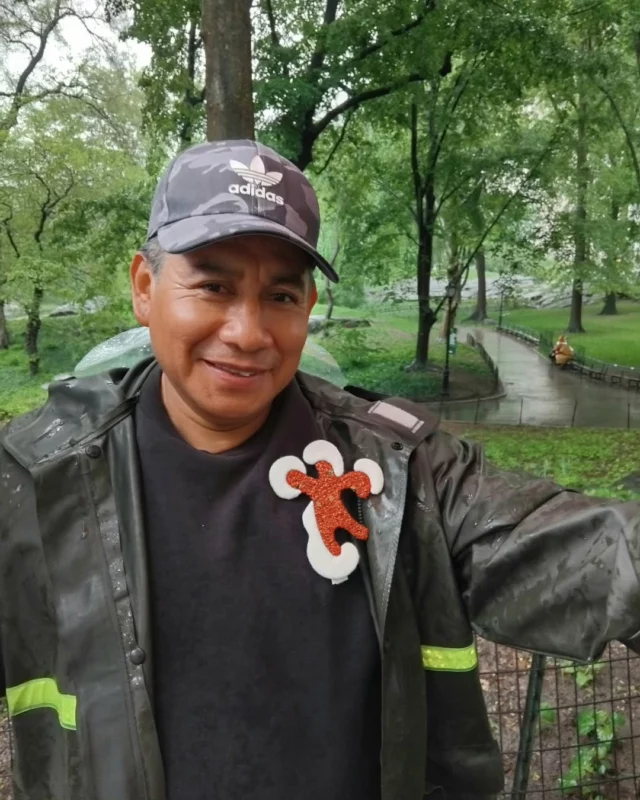 Chaque matin, pour me rendre @mad_aboutjewelry  à Columbus Circle, j'ai la chance de traverser une petite partie de Central Park. 
J'ai décidé que je proposerai à une personne rencontrée dans le parc, de poser avec une de mes broches exposée au musée pour l'événement. Je lui poserai une question, toujours la même : "What makes you feel alive today?"
Pas facile le matin de trouver le ou la candidate parmi le flot de trotteurs qui sillonne les allées à cette heure. Chevaux, joggeurs, promeneurs, chiens...  Ce matin-là, après avoir essuyé deux refus polis sous une pluie battante, il y avait Javier, que vous voyez sur la photo, debout sous son parapluie à côté de son chariot de travail. Bon, je l'ai un peu dérangé, son regard attentif m'a vraiment encouragée. Parmi les trois broches que j'avais apportées, j'ai choisi pour lui avec son accord, ma petite lutteuse Rickie.  A ma question, il a répondu :
"I'd like to earn money".